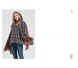 Detail view of navy plaid hooded poncho with colorful dots, fringe hem and soft knit texture