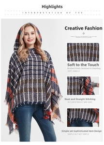 Detail of soft boucle yarn plaid hooded poncho featuring brushed texture and tassel hem
