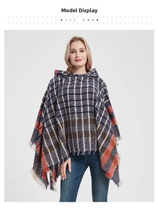Detail view of plaid knit poncho featuring long tassels and hooded neckline for autumn