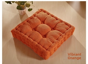 Detail of vibrant orange corduroy chair cushion with nine-hole tufted design