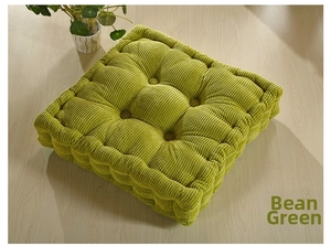 Detail of pea green square corduroy cushion showing 9-hole stitching and thick texture