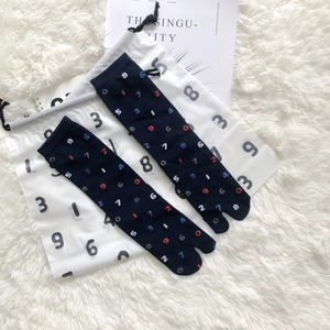 Close-up of dark blue Tabi split-toe socks with colorful number prints on plush fabric
