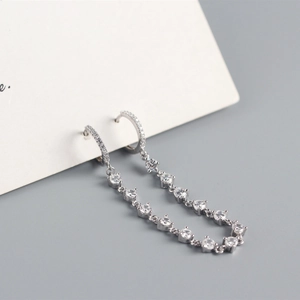 Macro shot of silver S925 earrings with sparkling luxury long tassel diamond pendants