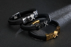 Detailed view of woven leather bracelets with crystal-encrusted metal cross buckles
