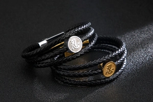Macro view of braided leather layers and round steel charms with kanji engraving