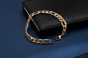 Vue macro du bracelet Figaro bicolore avec fermoir mousqueton sur fond en cuir noir