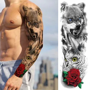 Detail view of full arm temporary tattoo with wolf, owl and red rose designs