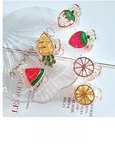 Detail of colorful acrylic fruit hair clips including strawberry and pineapple shapes