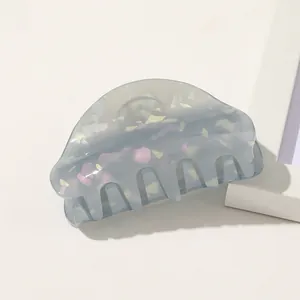 Detail of grey acetate hair claw clip with colorful glitter flakes on white background