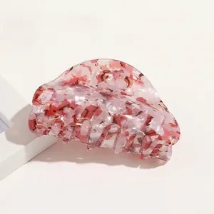 Close-up of pink and white marble pattern acrylic hair claw clip for elegant updos
