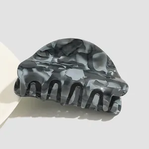 Close-up of large acetate hair claw clip with black marble shell pattern for updos