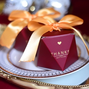 Elegant burgundy wedding gift boxes with gold heart pattern and golden ribbon ties