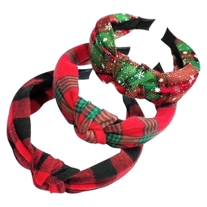 Detailed view of three knotted plaid headbands in red, green and snowflake patterns