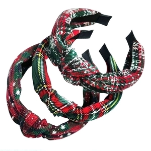Close-up of three Christmas red and green plaid knotted fabric headbands on white background