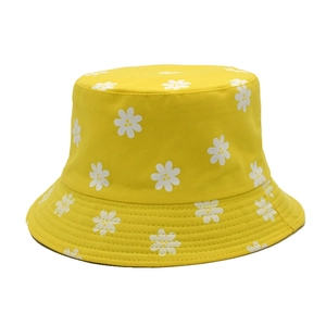 Détail d'un chapeau bob jaune en coton avec imprimé marguerites sur fond blanc uni