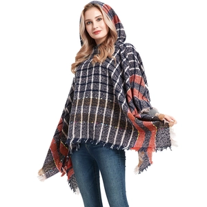 Women's hooded plaid poncho with fringe details in navy blue and red checkered pattern