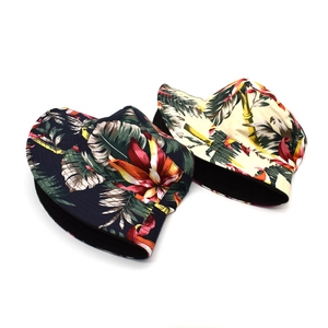 Dettaglio della stampa tropicale con foglie di palma su cappelli alla pescatora in cotone