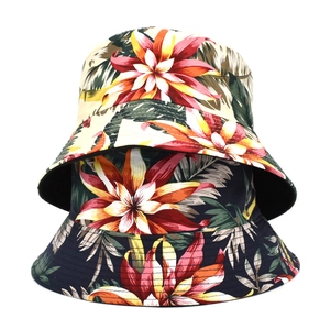 Dettaglio della stampa floreale tropicale su cappelli a secchiello in crema e blu