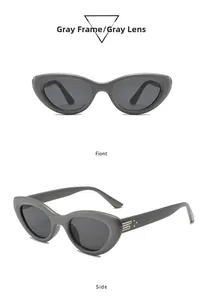 Detailed view of gray cat-eye sunglasses with gold metal bar accents on the temples