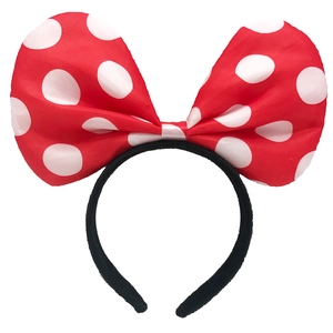 Close-up of a large red satin bow headband with white polka dots for girls' hair accessories