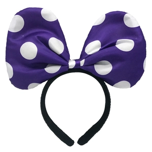Close-up of a large purple bow headband with white polka dots for girls