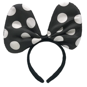 Close-up of a large black and white polka dot satin bow headband for girls hair accessory