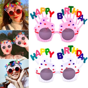 Close-up of pink cupcake birthday glasses with colorful Happy Birthday candle letters