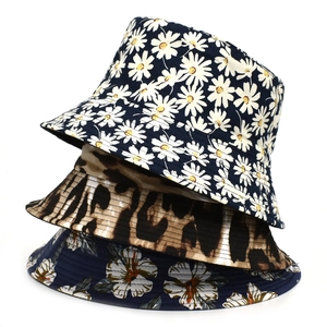 Vertical stack of three reversible sun hats with daisy, leopard, and floral prints