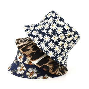Close-up of three bucket hats with daisy, leopard, and floral prints in cotton canvas