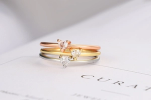 Tre anelli impilabili con zirconi a forma di cuore in oro, argento e oro rosa