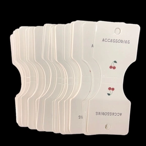White cardboard accessory display cards with red cherry icons for hair accessories