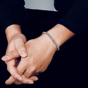 Minimalist silver stainless steel box chain bracelet for men on model with dark background