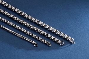Detailed comparison of four silver box chains in various widths on blue surface