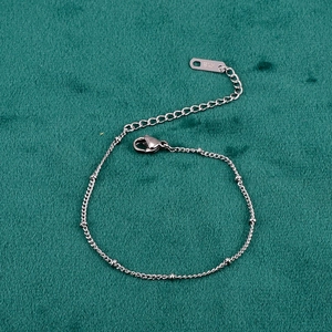 Macro view of 18K silver bead chain bracelet featuring a lobster clasp and k18 engraving