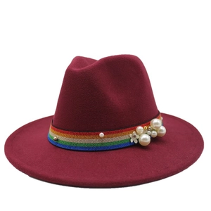 Macro detail of wine red fedora hat featuring rainbow ribbon and elegant pearl accents
