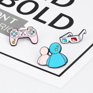 Macro detail of enamel pins featuring a pink game controller, 3D glasses, and cartoon figure