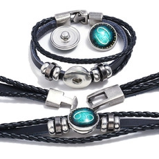Detail of braided leather bracelet with Cancer zodiac sign charm and silver buckle
