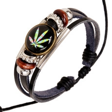 Macro shot of multi-layer leather bracelet with hemp leaf pattern on glass dome