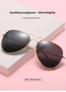 Classic aviator sunglasses with gold metal frame and dark grey lenses on pink backdrop
