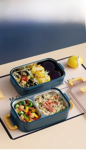 Detail of 304 stainless steel lunch box showing food compartments and yellow buckles