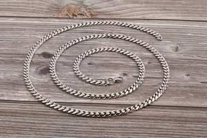 Detailed view of silver Cuban link body chain with secure lobster clasp on wood texture
