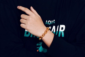 Detail of a minimalist gold stainless steel O-chain bracelet on a model wrist