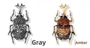 Detail view of beetle pins in grey and champagne colors with sparkling crystals