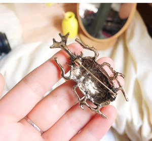 Close-up of the vintage beetle brooch back showing the secure safety pin clasp