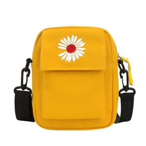 Yellow canvas crossbody bag with white daisy embroidery and black nylon strap