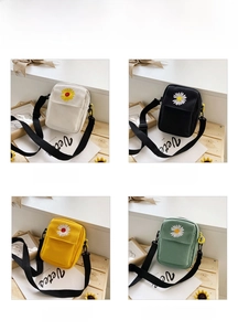 Detail of daisy embroidery on canvas crossbody bags in white, black, yellow and mint
