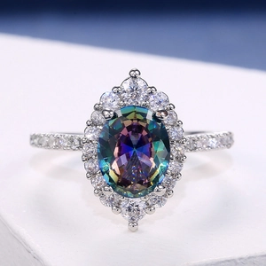Macro shot of oval rainbow topaz ring with halo diamonds in silver-white metal setting