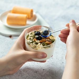 Cucchiaio in vetro termoresistente per servire mirtilli freschi da uno yogurt con cereali