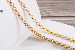 Detail of interlocking gold-plated rings showing high-gloss finish on body chain