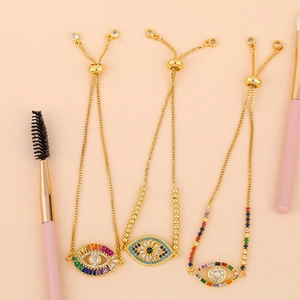 Detailed close-up of colorful crystal evil eye charms on adjustable gold bracelets